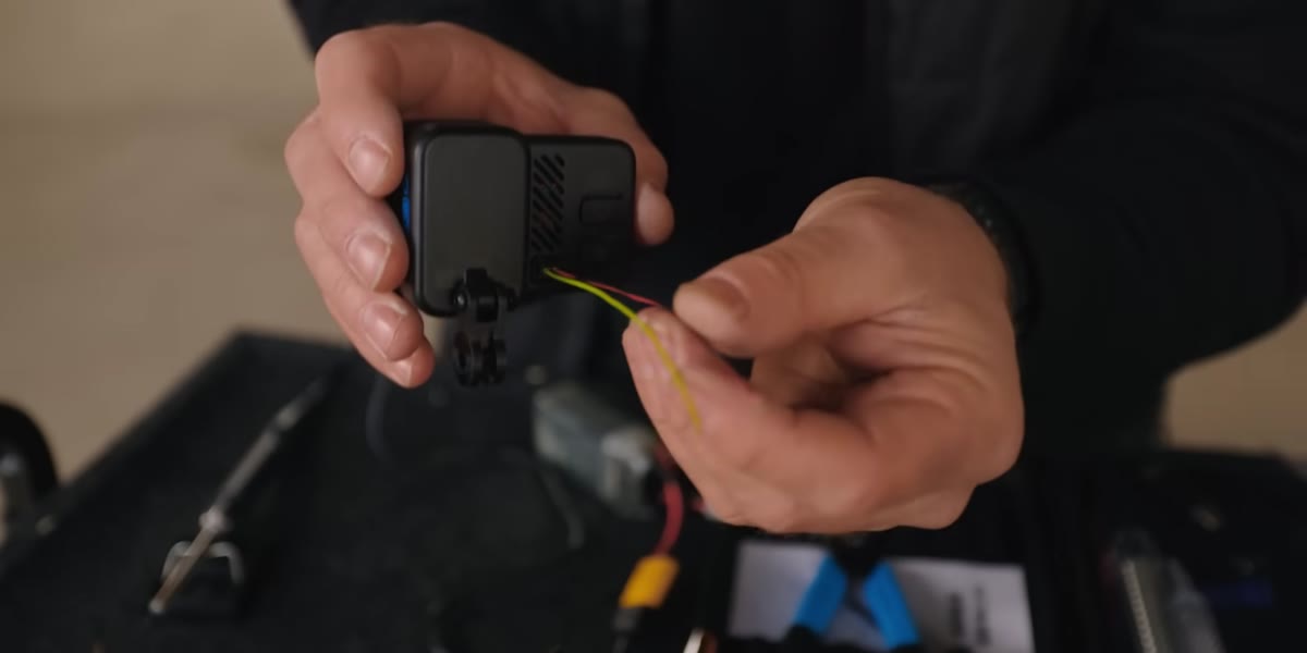 Kristoff soldering power leads from the drone battery to the Bones board