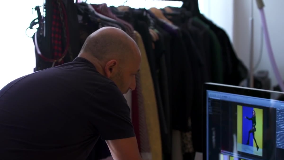 Photographer reviewing image on camera, pointing out hand position issue