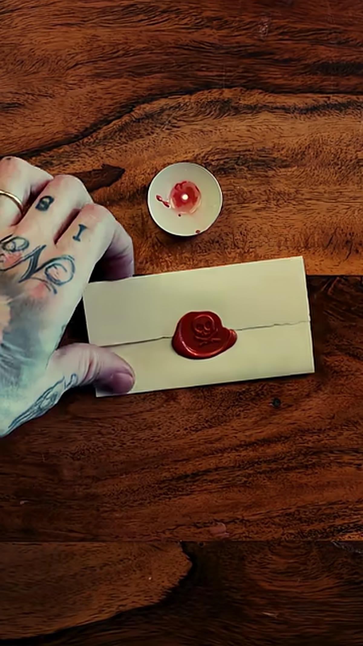 Stamp being lifted to reveal finished wax seal impression