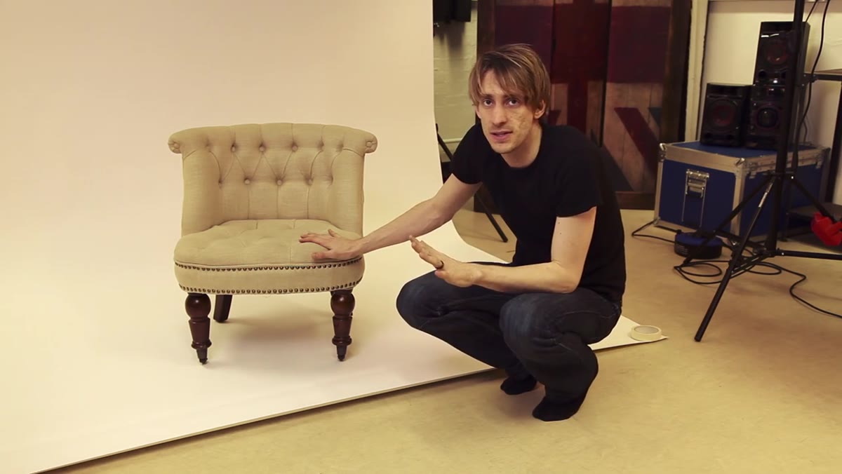Sean Tucker gesturing toward white paper taped to floor