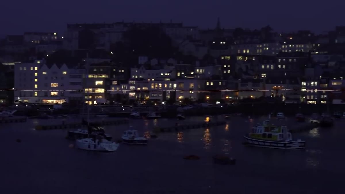Harbour scene at twilight with layered buildings lit up