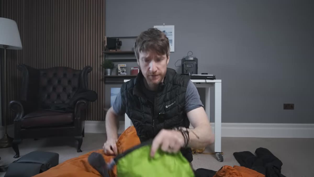 Large down jacket being compressed into a small stuff sack
