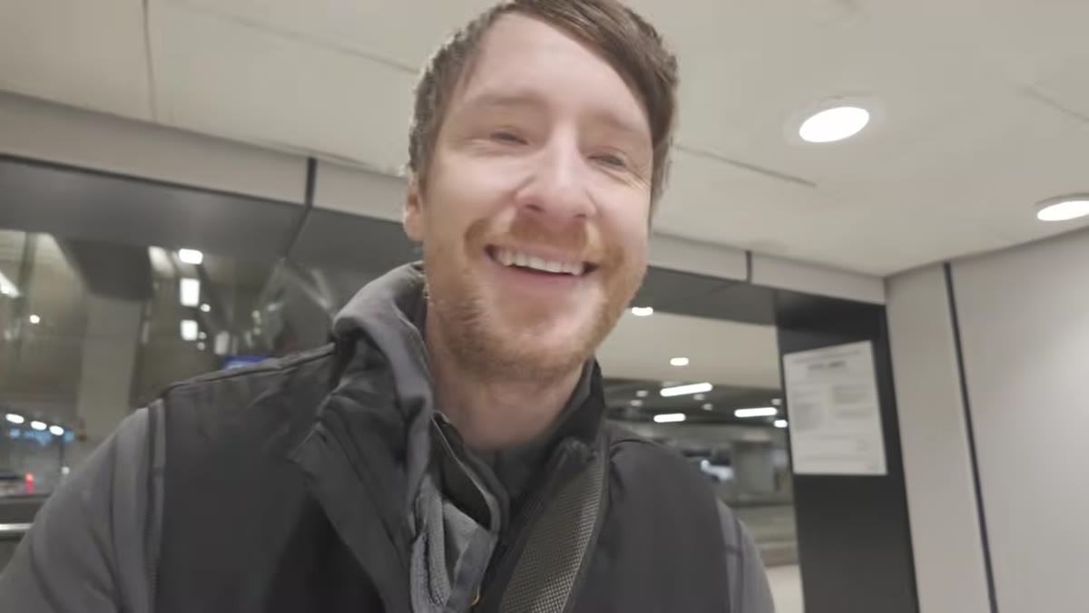 Thomas Heaton approaching the airport check-in desk with an oversized camera bag