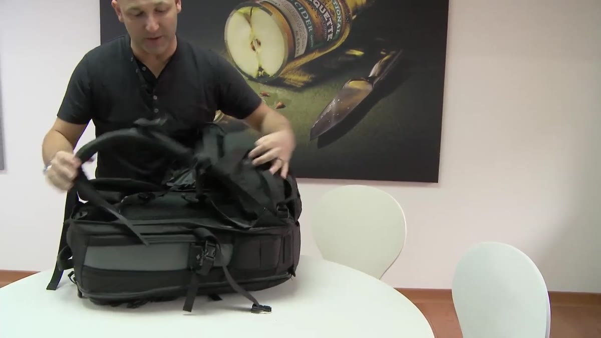 Taylor demonstrating the strap tuck-away cover on the back of the bag