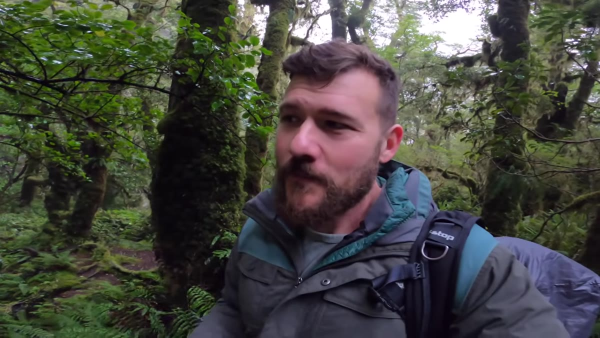 Photographer pausing to study trees behind the waterfall