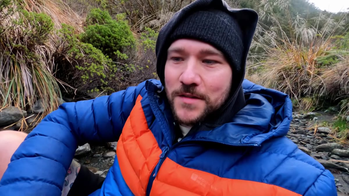 Patino repositioning in a creek to capture water reflection below the kea
