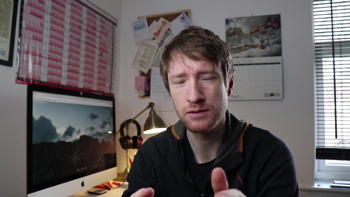 caption: Heaton explaining his choice of unframed foam board mounting