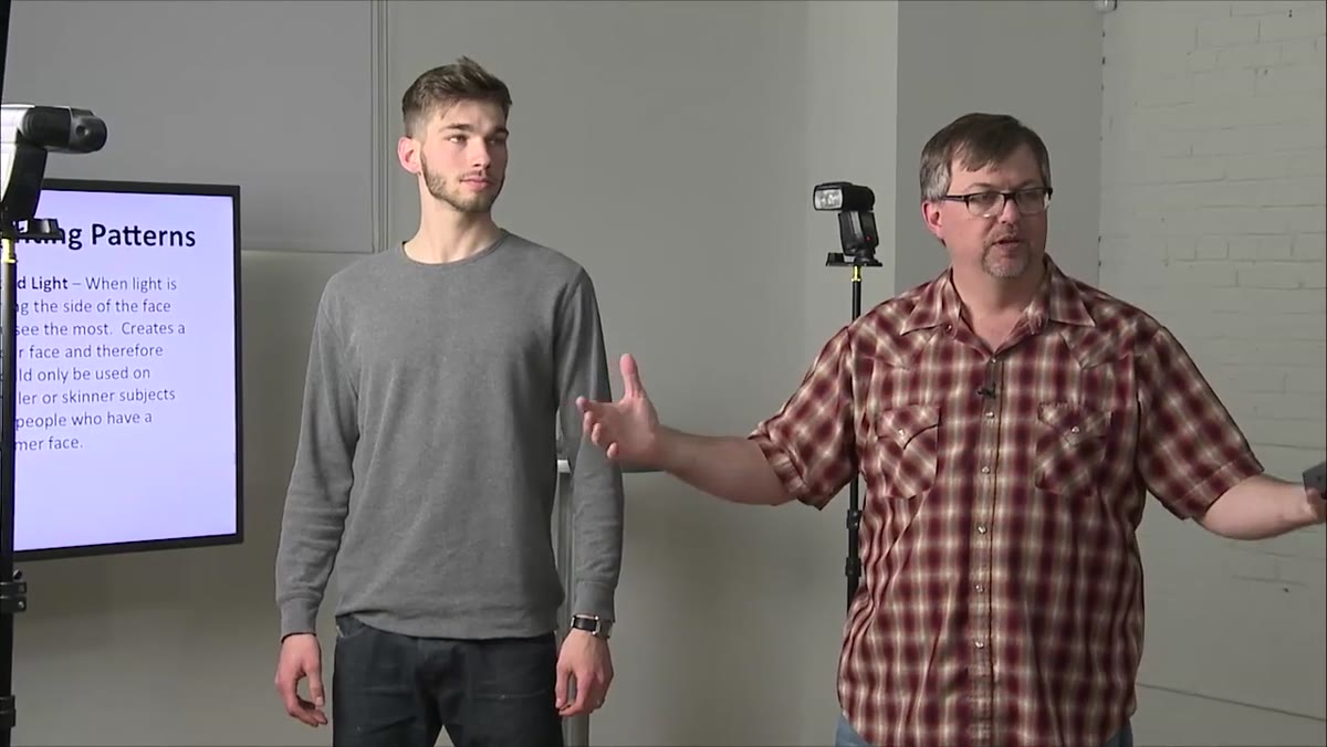 Instructor positioning male subject sideways toward softbox light