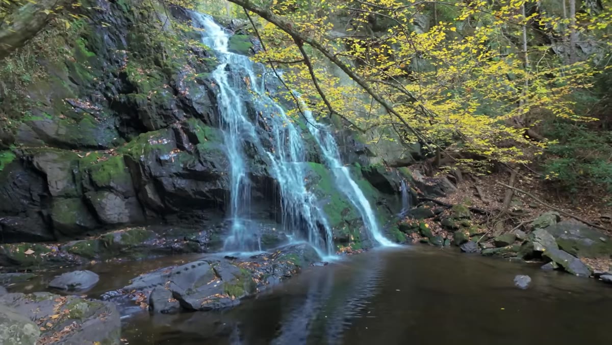 Photographer scanning the waterfall scene and surrounding ridge