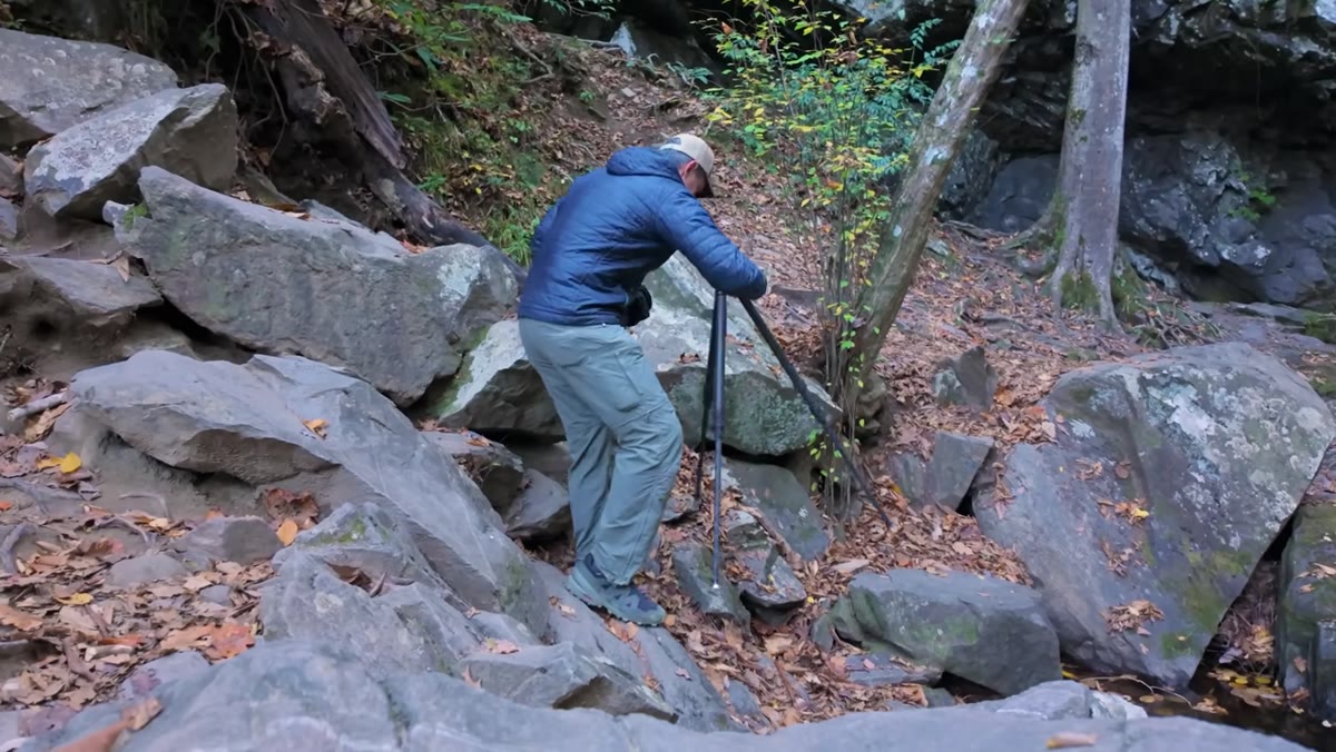 Camera mounted on tripod with wide-angle lens facing the waterfall
