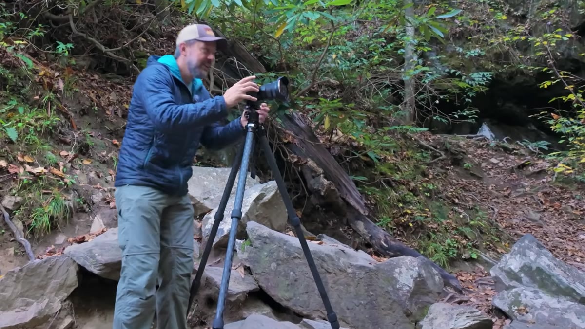 Mark settling tripod into final position, reviewing composition on camera