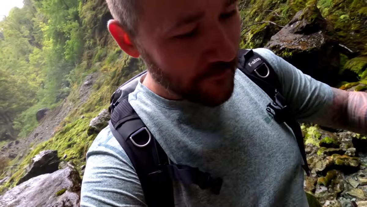 Photographer moving around corner toward possible cave formation