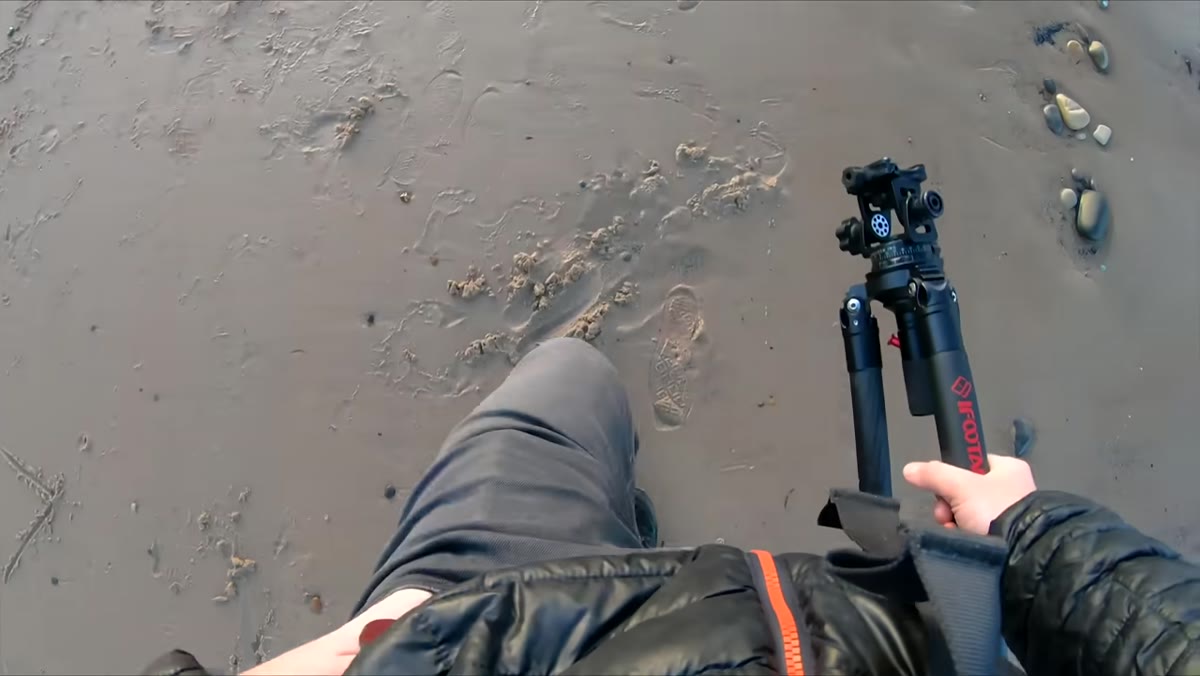 Heaton walking the beach, scanning the sand as the tide pulls back