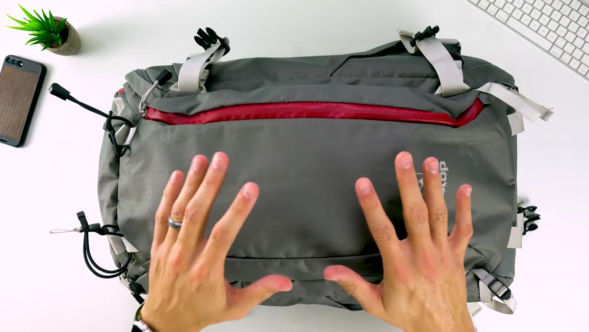 Mark demonstrating the weather-sealed zipper closure on the bag