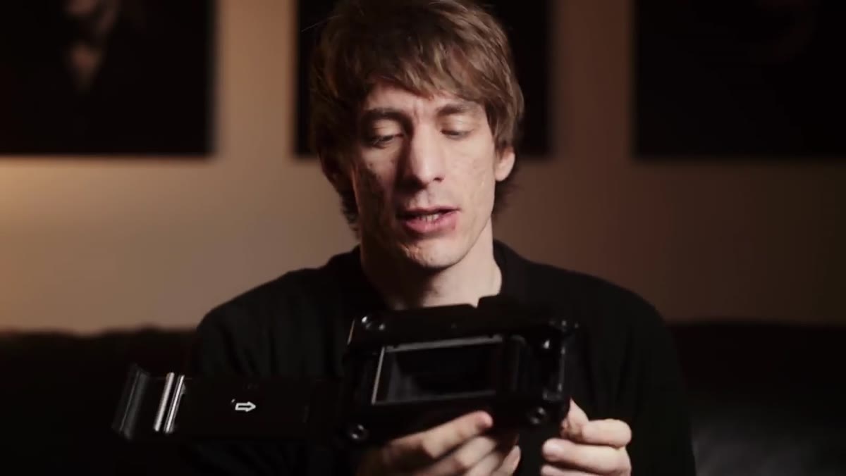 Photographer adjusting camera settings by window light