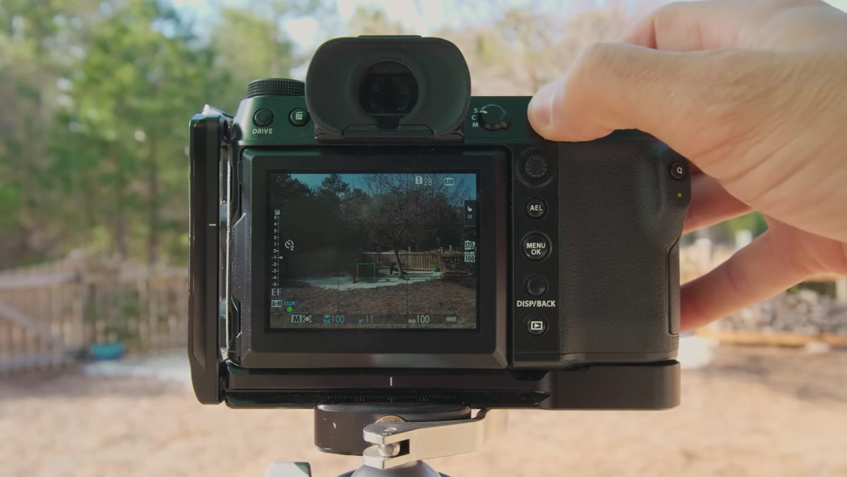 Photographer reducing exposure until highlight blinkies disappear from live view