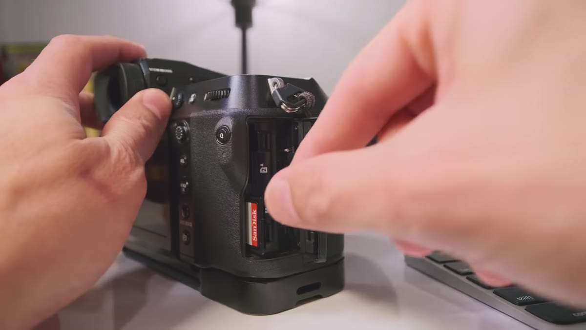SD card being inserted into a laptop card reader