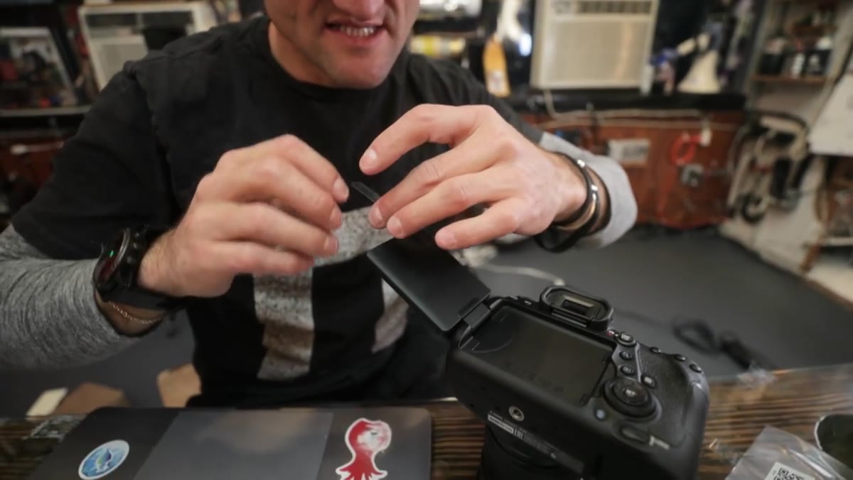 Tape being pressed onto inside face of folded swivel screen
