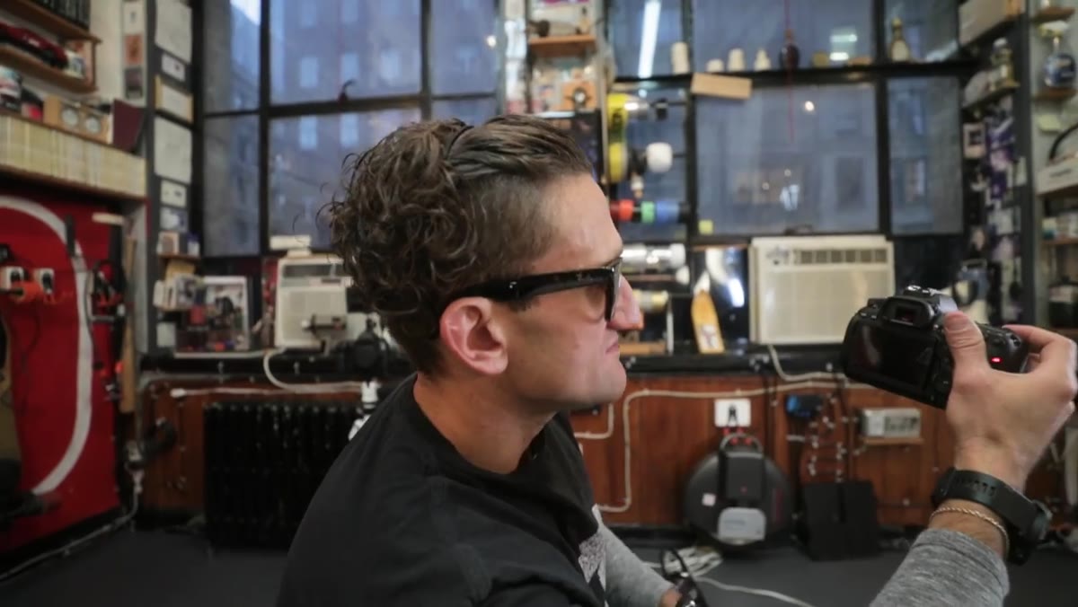 Hand pulling screen open smoothly using the tape tab while holding camera