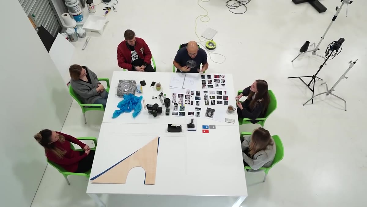 Behind-the-scenes activity with multiple people moving around the set