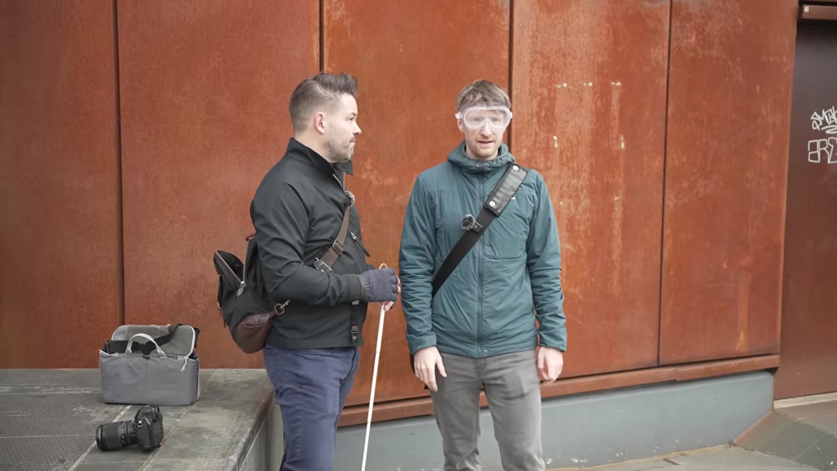Thomas wearing Vaseline goggles listening to approaching footsteps and trolley wheels