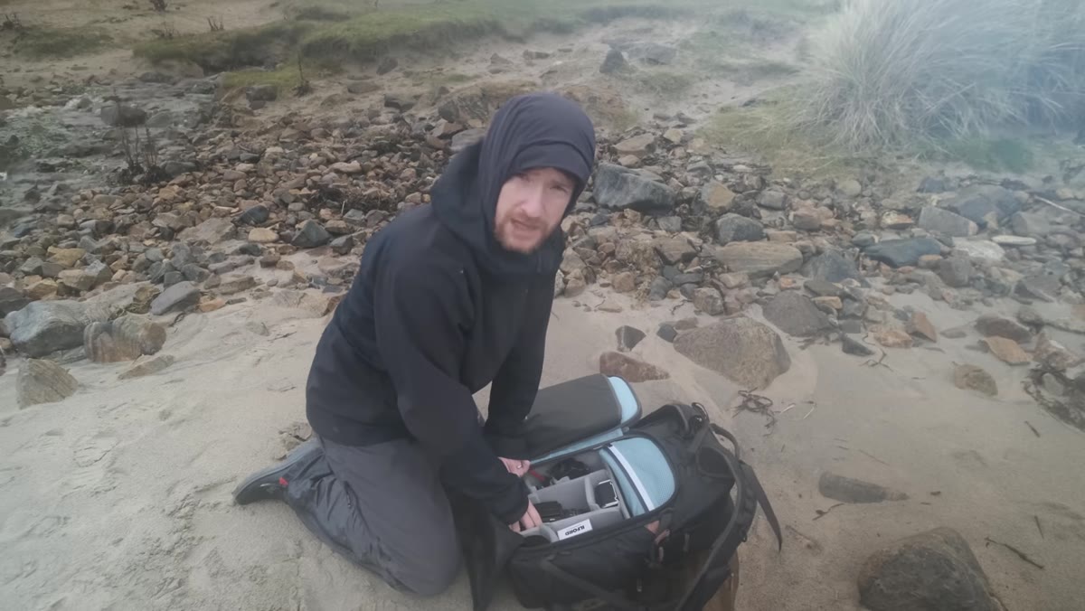 Heaton looking at his feet on the beach, searching for texture