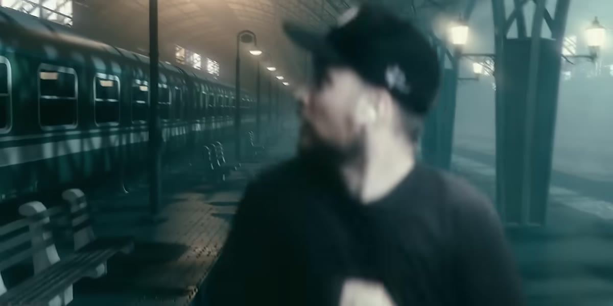 Background train blurs as subject moves, then refocuses