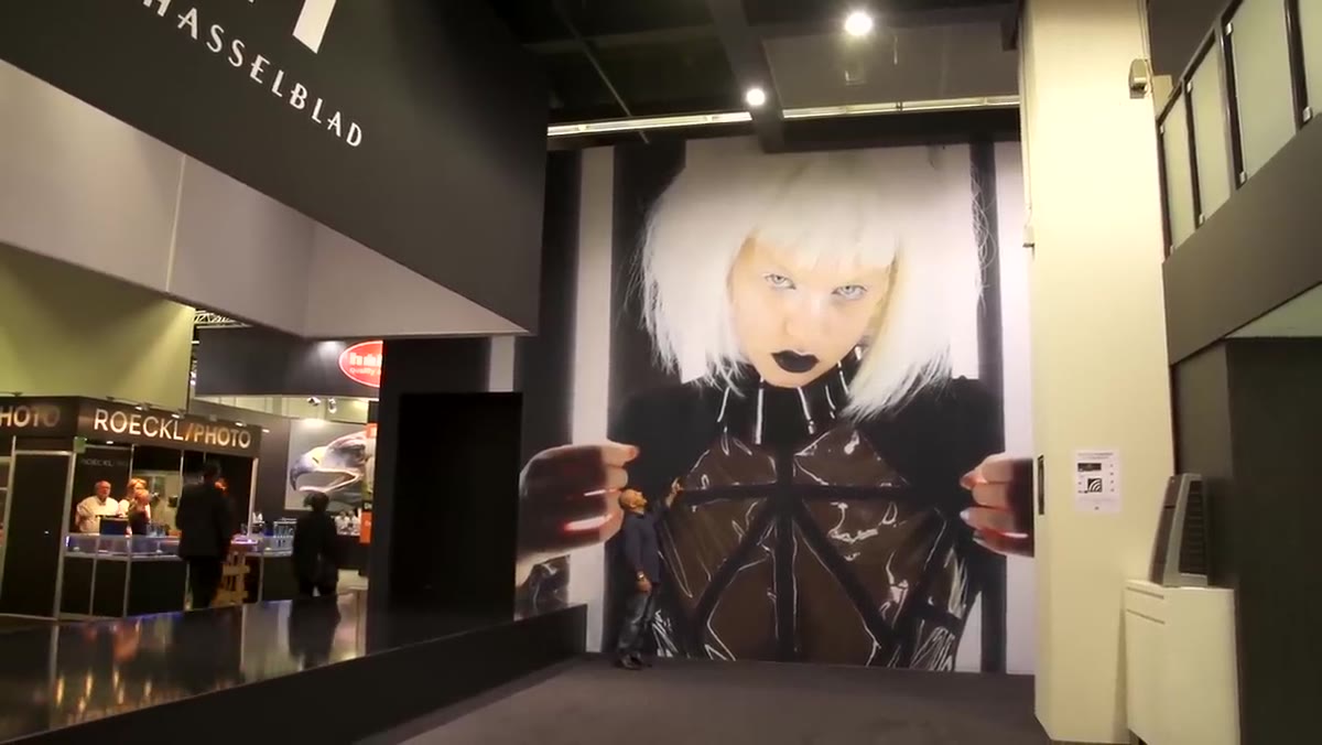 Carl Taylor standing beside a massive wall print