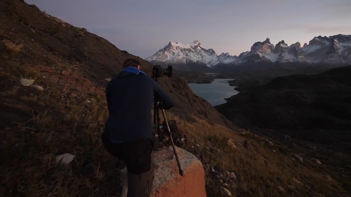 Heaton adjusting exposure settings at dawn in Torres del Paine