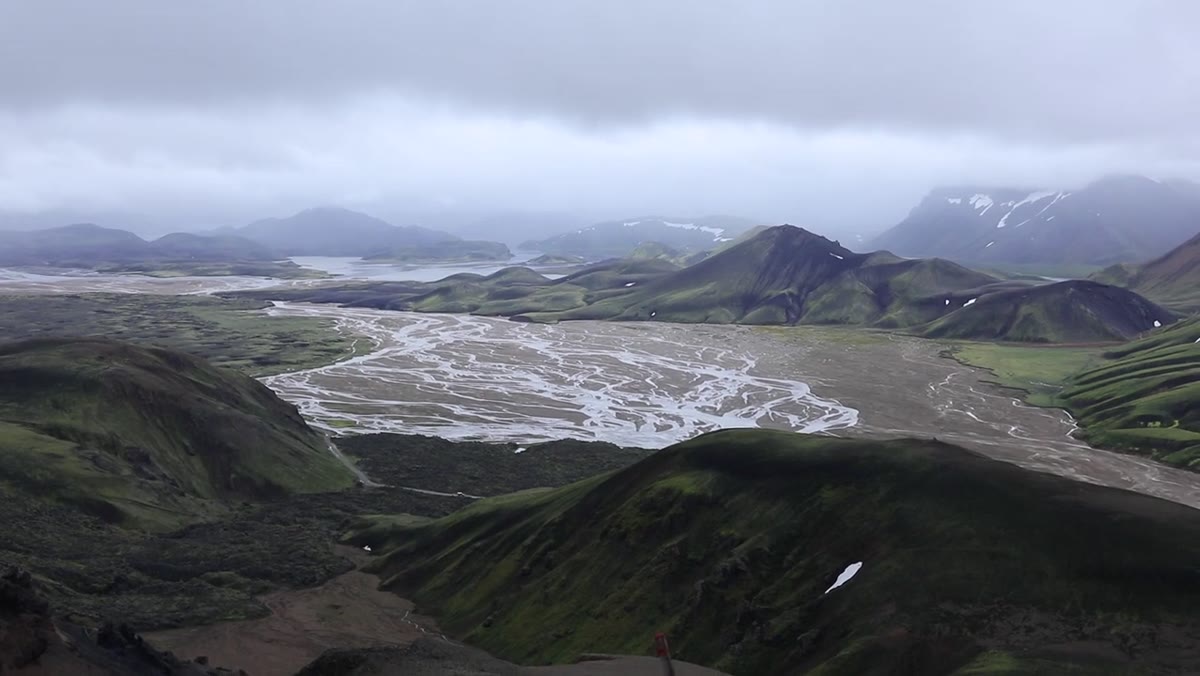 Heaton gesturing toward the valley below, comparing high and low viewpoints