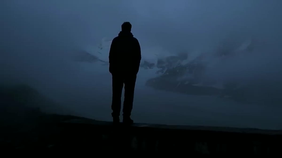 Thomas looking out at fog-covered landscape before sunrise